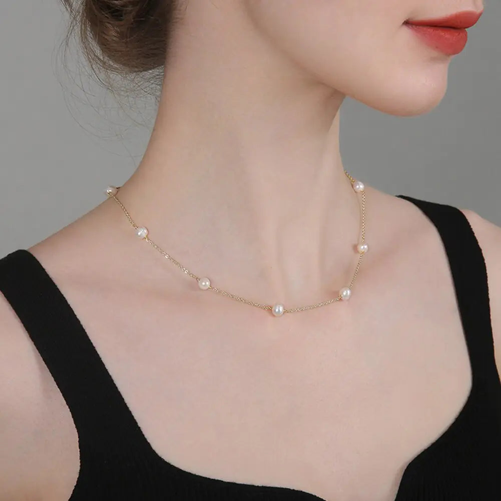 Luna Pearl Necklace styled on a model wearing a black top, emphasizing its timeless elegance and versatile design.
