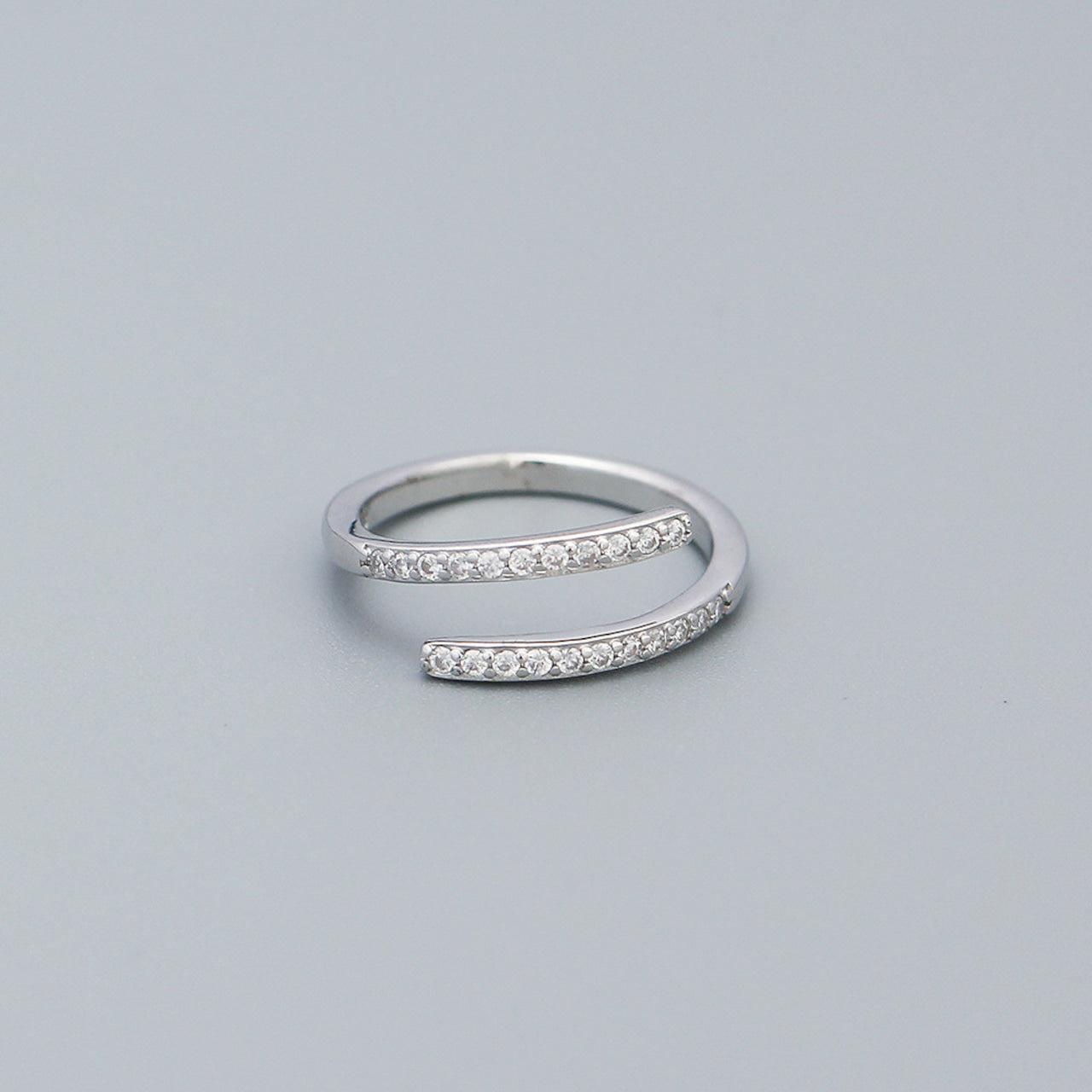 Orbit Ring - Minimalist sterling silver open-wrap ring with sparkling cubic zirconia accents, embodying Nordic simplicity and modern elegance.