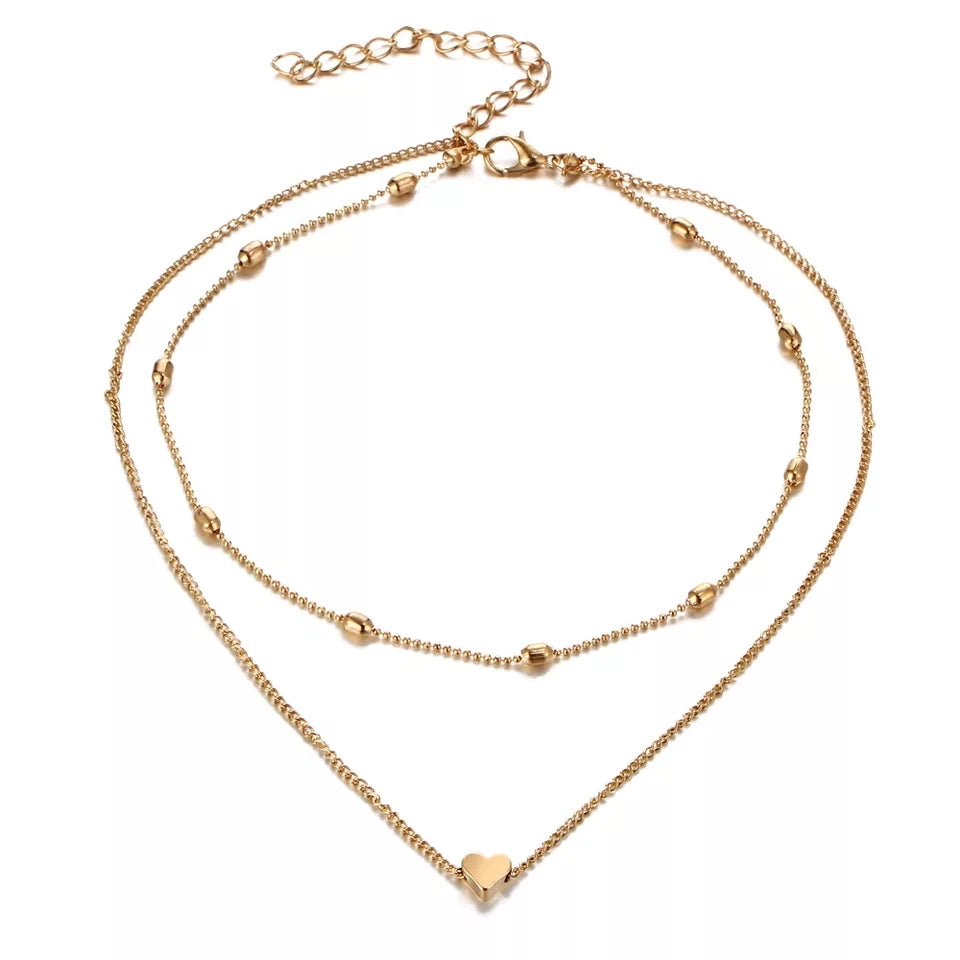 Gold Fiora Heart Necklace with layered chains, showcasing a dainty heart charm and adjustable clasp for an elegant and romantic look.