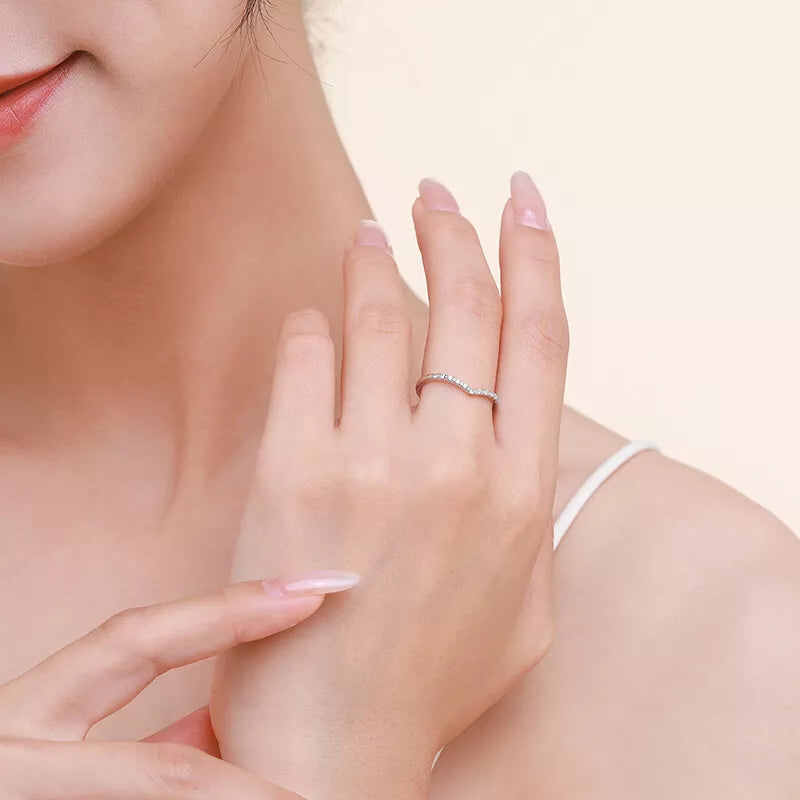 Woman wearing the Lunaire Ring, a sterling silver V-shaped ring with cubic zirconia. A delicate and sophisticated jewelry piece for everyday elegance.