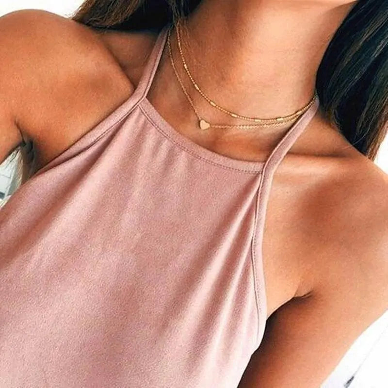 Gold Fiora Heart Necklace styled on a model with a halter top, emphasizing its layered elegance and romantic heart charm.
