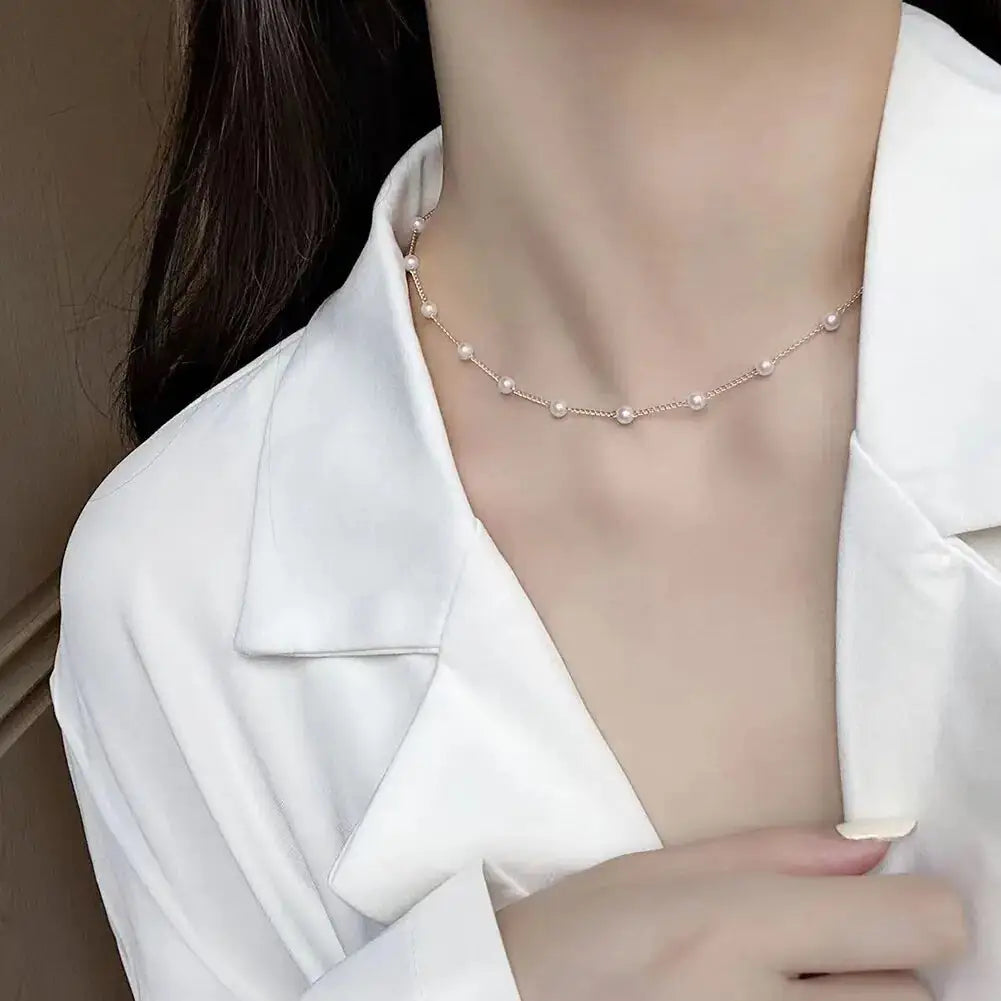 Luna Pearl Necklace paired with a white blouse, showcasing its classic pearls and gold chain for a chic and polished look.