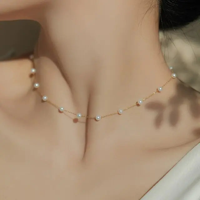 Luna Pearl Necklace worn on a model, showcasing its delicate gold chain and pearls that add sophistication to any outfit.